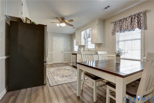 a kitchen with stainless steel appliances granite countertop a refrigerator a sink dishwasher and a black countertop next to a window