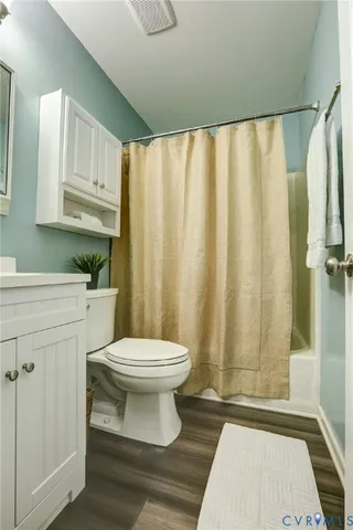 a bathroom with a sink a toilet a window and shower