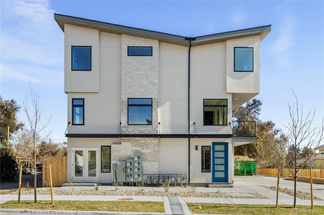 a front view of a house with garage and plants