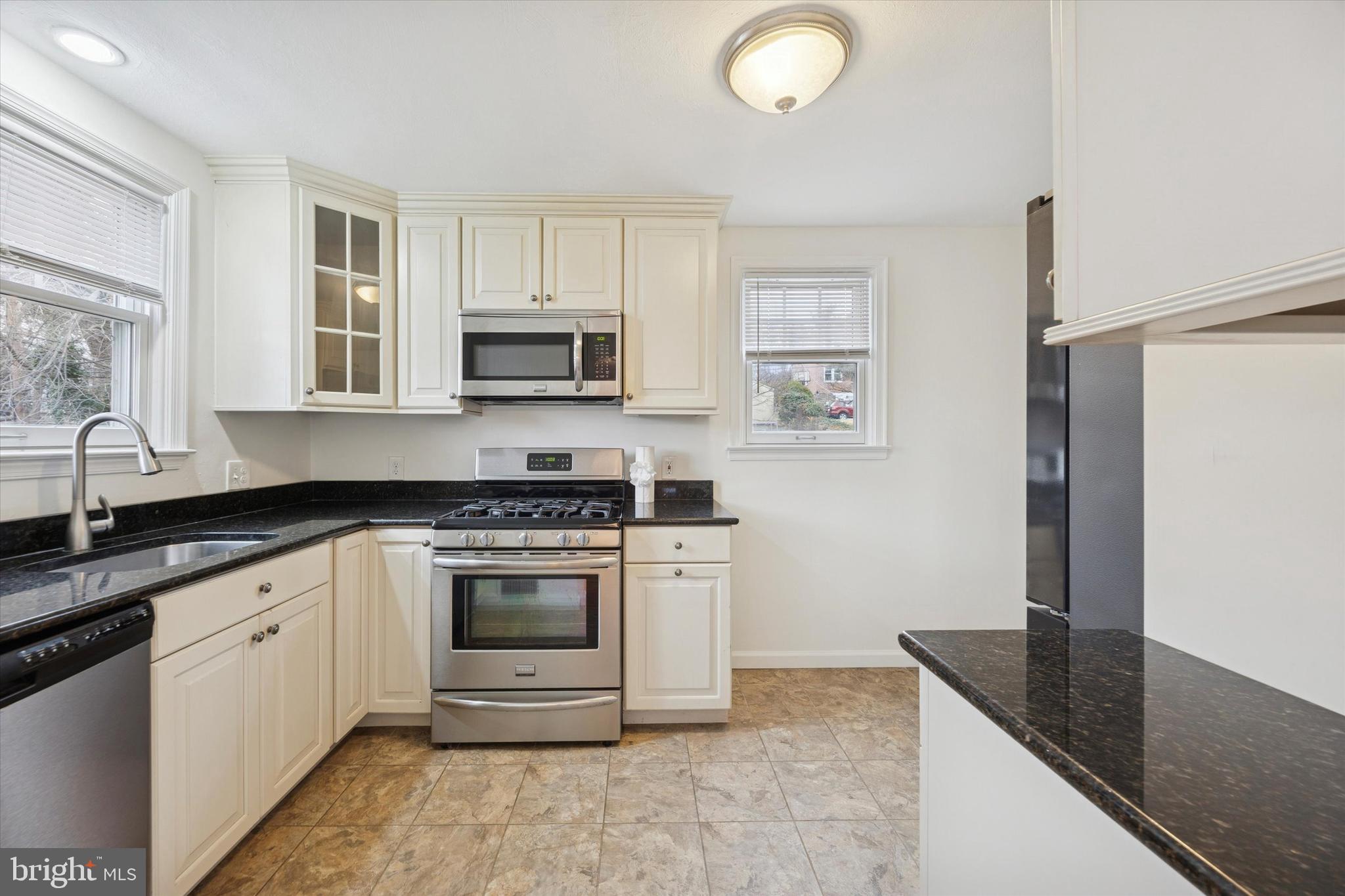 519 Acorn Street Philadelphia, PA 19128 - Photo 14 of 29 a kitchen with granite countertop a stove sink and microwave