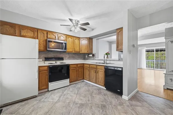 a kitchen with stainless steel appliances granite countertop a refrigerator a sink dishwasher a stove with wooden cabinets and floor