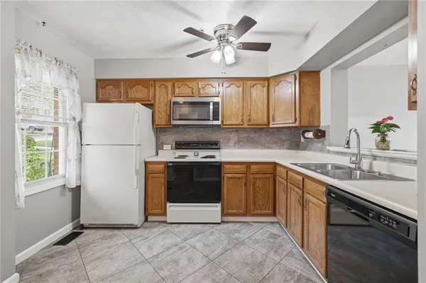 a kitchen with stainless steel appliances granite countertop a stove a sink and a refrigerator