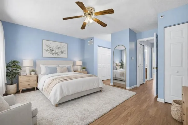 a view of a livingroom with a ceiling fan wooden floor and a ceiling fan