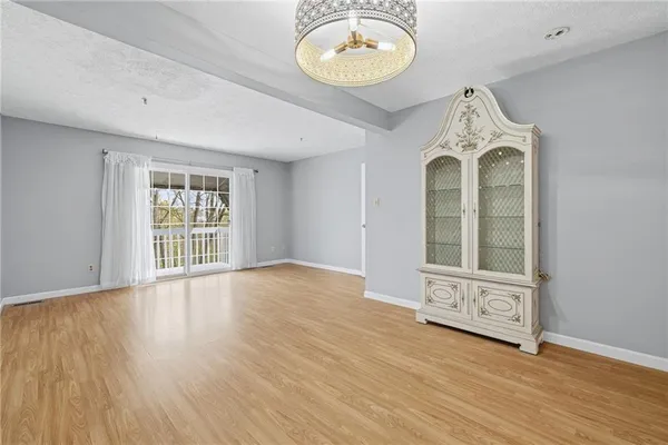 an empty room with wooden floor windows and glass door