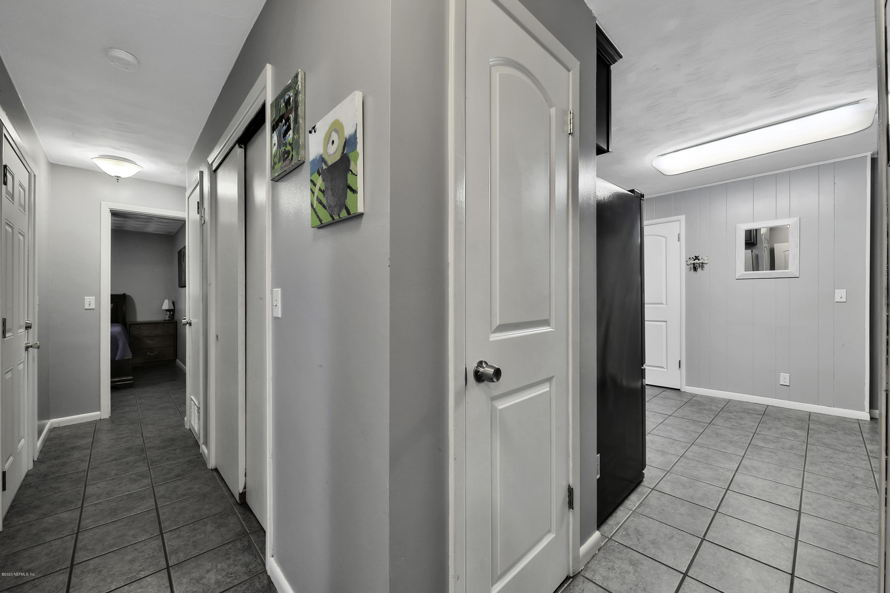 6161 Carlton Road Jacksonville, FL 32244 - Photo 11 of 26 a view of a hallway with wooden floor and a bathroom