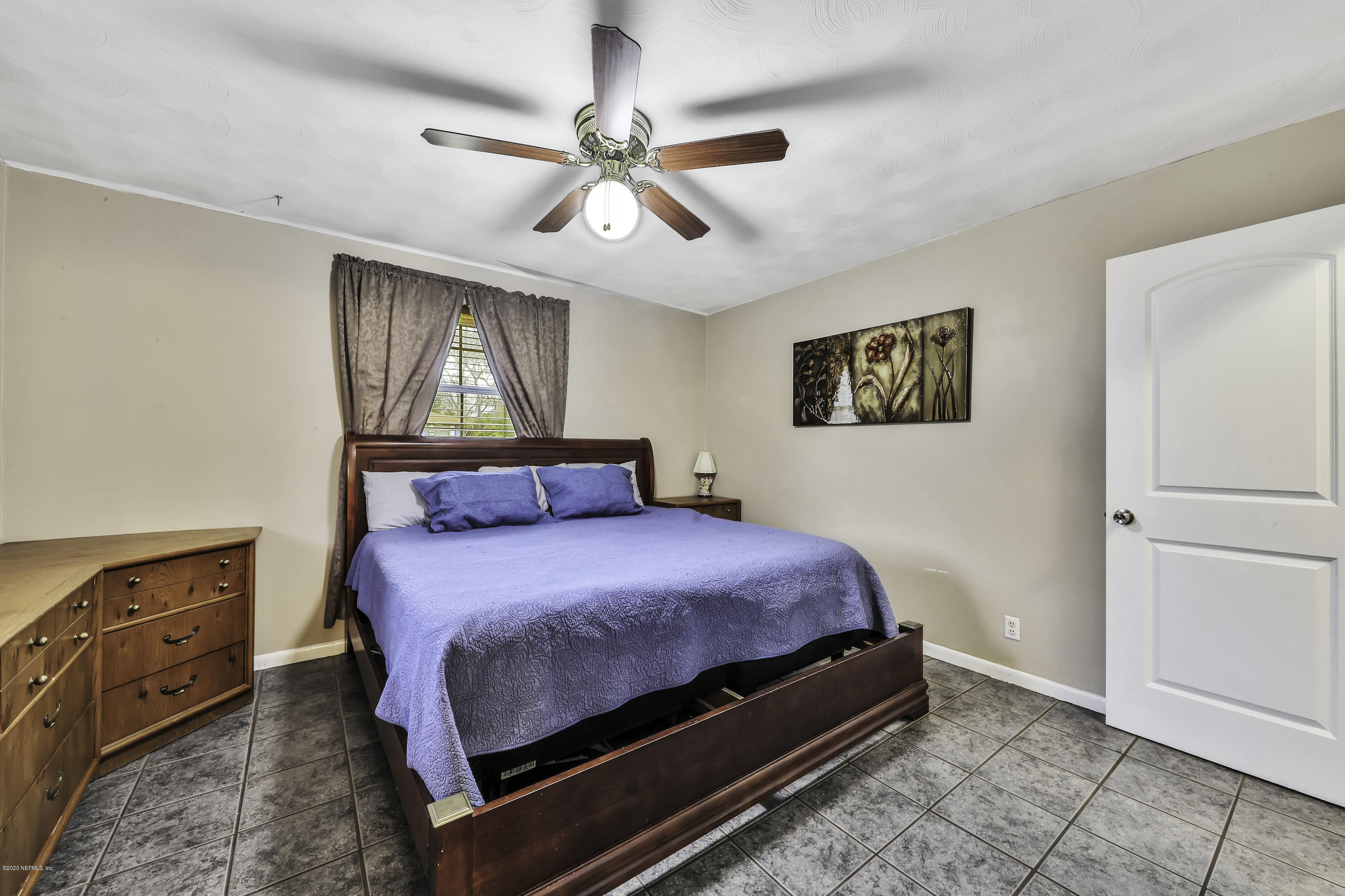 6161 Carlton Road Jacksonville, FL 32244 - Photo 13 of 26 a bedroom with a bed dresser and wooden floor