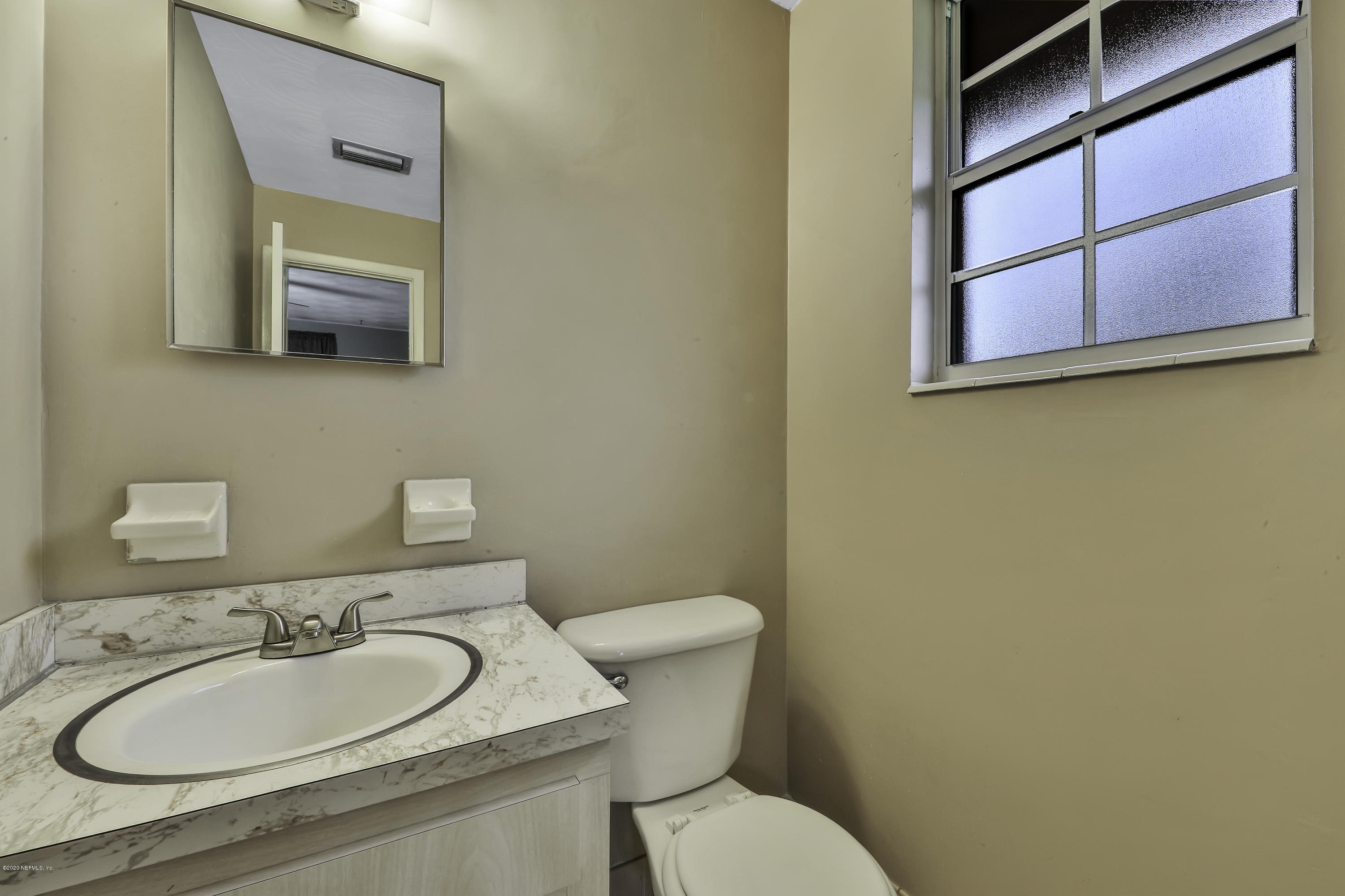 6161 Carlton Road Jacksonville, FL 32244 - Photo 14 of 26 a bathroom with a granite countertop toilet sink and mirror