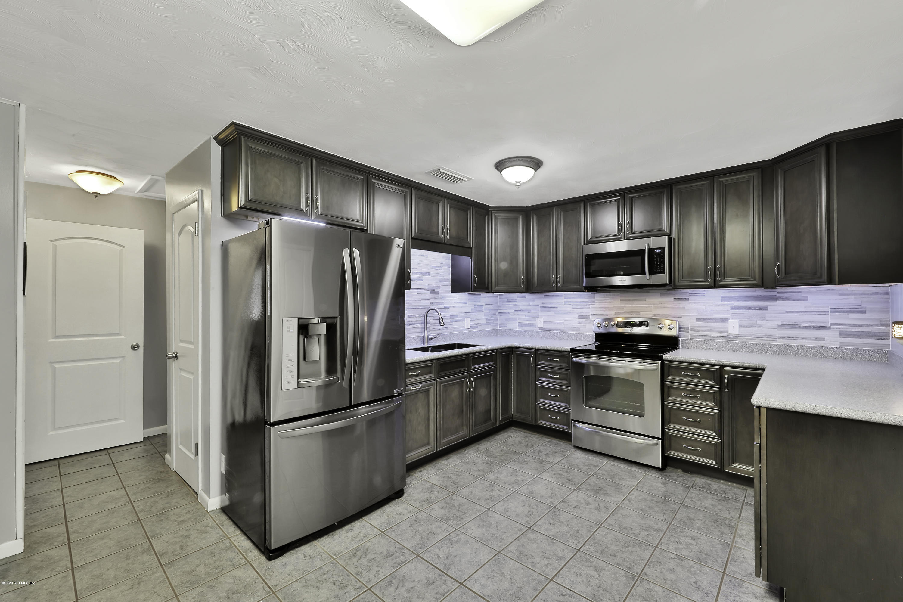 6161 Carlton Road Jacksonville, FL 32244 - Photo 4 of 26 a kitchen with granite countertop stainless steel appliances cabinets and a counter top space