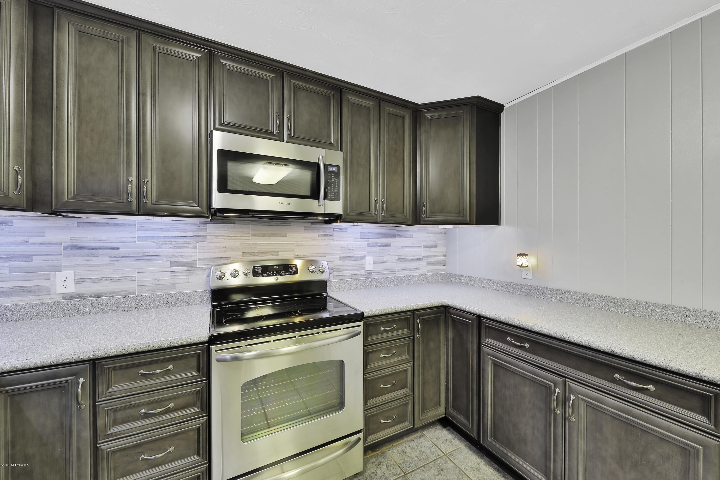 6161 Carlton Road Jacksonville, FL 32244 - Photo 5 of 26 a kitchen with granite countertop cabinets stainless steel appliances and green counter space