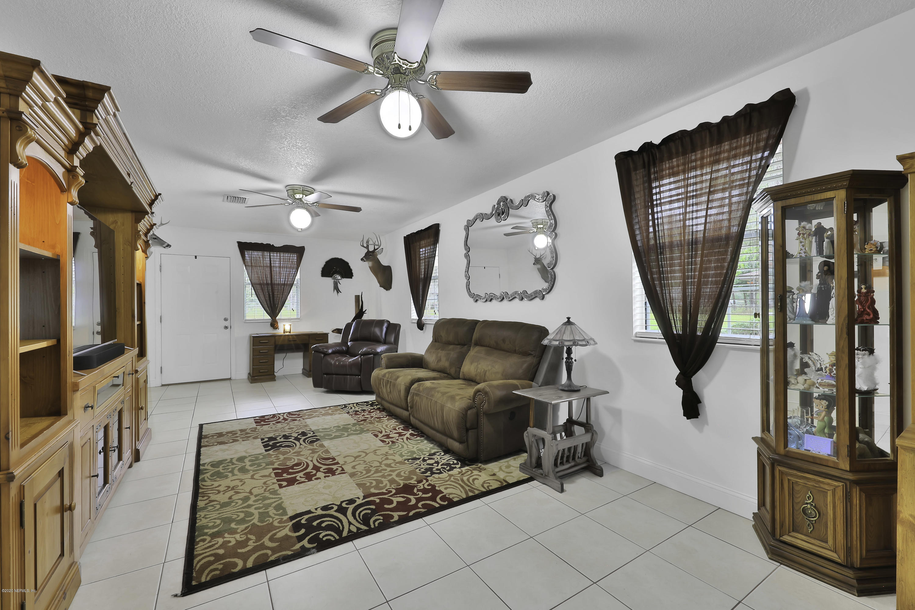 6161 Carlton Road Jacksonville, FL 32244 - Photo 8 of 26 a living room with furniture a flat screen tv and a window