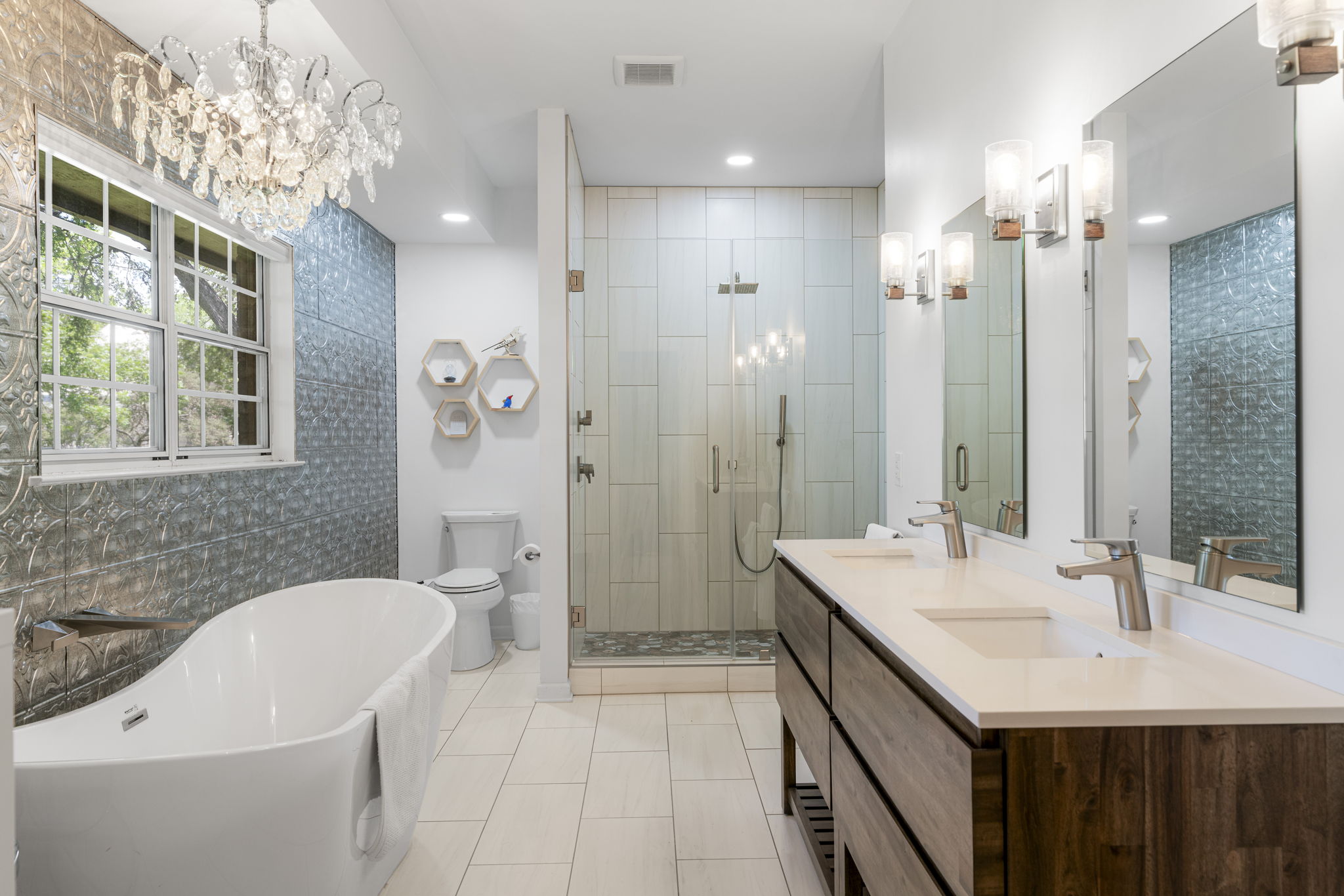 400 Hackberry Street Lockhart, TX 78644 - Photo 24 of 40 Luxurious bathing quarters feature a crystal chandelier, freestanding tub, and spacious walk-in shower.