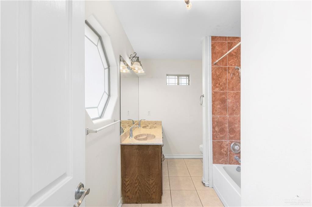 240 East Dicker Road Pharr, TX 78577 - Photo 10 of 23 Bathroom featuring a dual-sink vanity with a light-colored countertop and wood-finish cabinetry