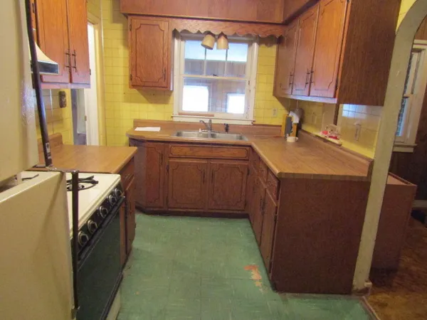 a kitchen with a sink stove top oven and a window