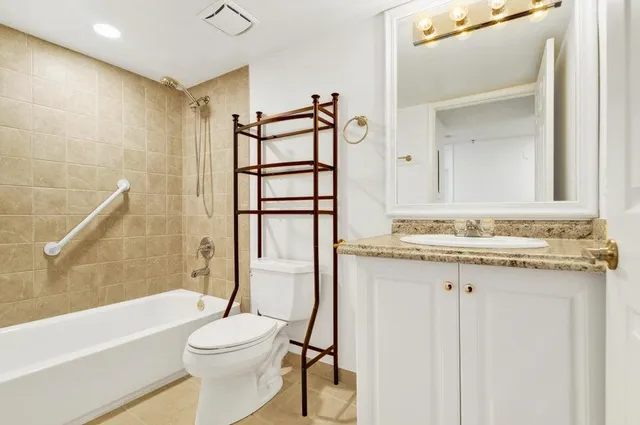 a bathroom with a granite countertop sink toilet and shower