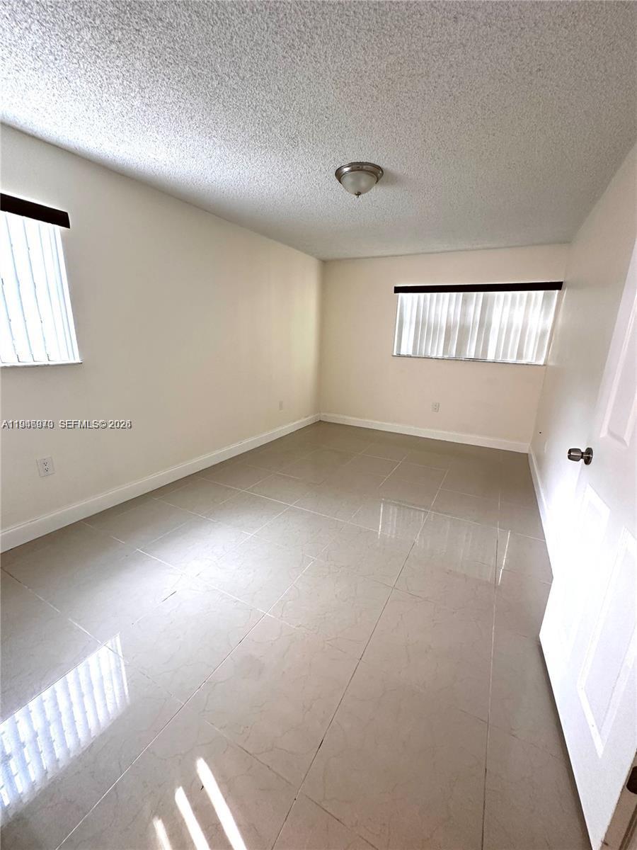 919 Northeast 199th Street, Unit 104 Miami, FL 33179 - Photo 11 of 19 a view of an empty room and window