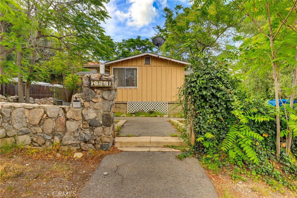 7264 Hillrose Street Tujunga, CA 91042 - Photo 4 of 27 a pathway of a house with potted plants in front of it