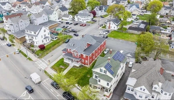an aerial view of a house with a yard and outdoor seating