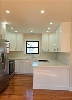 31 Niagara Street Fall River, MA 02721 - Photo 4 of 12 a view of a kitchen with a sink and dishwasher a stove top oven with wooden floor