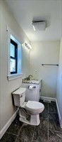31 Niagara Street Fall River, MA 02721 - Photo 6 of 12 a bathroom with a granite countertop toilet a sink and a mirror