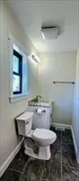 a bathroom with a granite countertop toilet a sink and a mirror
