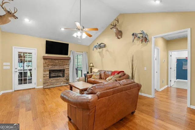 a view of a dining room and livingroom with furniture a rug a fireplace and a chandelier