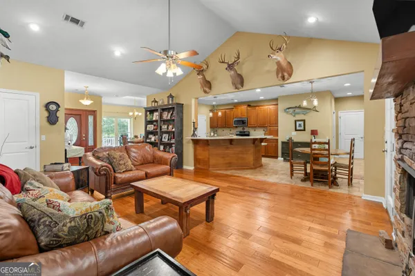 a kitchen with stainless steel appliances granite countertop a sink a stove a refrigerator cabinets and living room view