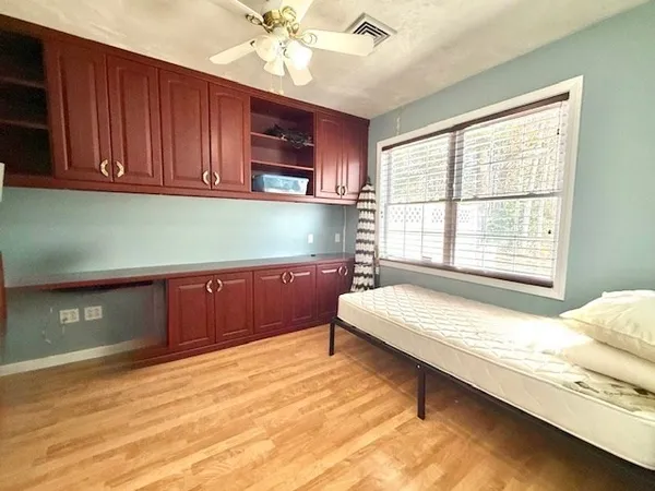 a spacious bedroom with a bed and wooden floor