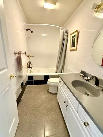 a bathroom with a double vanity sink toilet mirror and shower