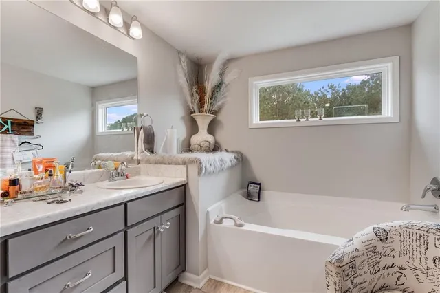 a bathroom with a tub sink and mirror