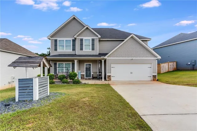 a front view of a house with yard outdoor seating and garage