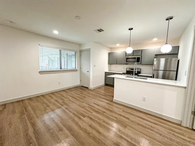 a kitchen with stainless steel appliances granite countertop a stove a sink and a refrigerator
