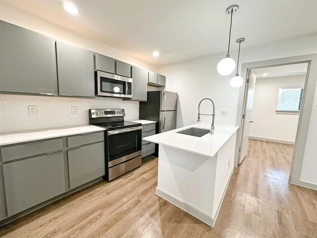 a kitchen with a sink stove and refrigerator