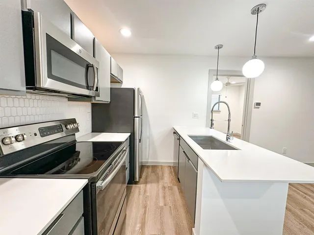 a kitchen a sink a stove and a refrigerator