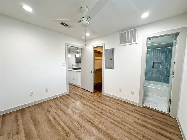 wooden floor in an empty room with a bathroom