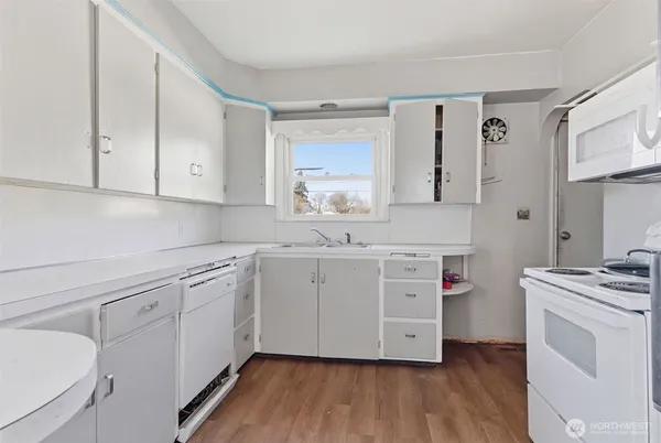 a kitchen with cabinets wooden floor and a sink