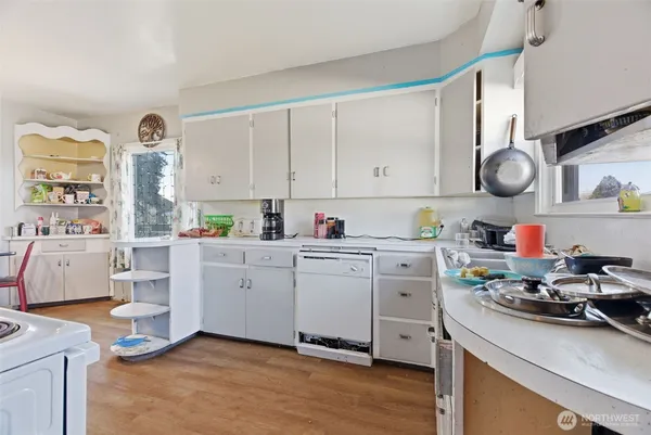 a kitchen with white cabinets and white appliances