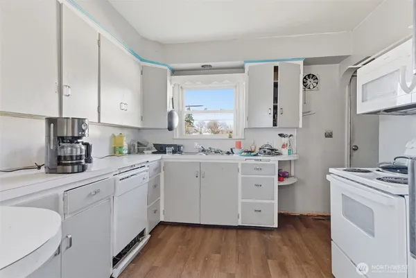 a kitchen with white cabinets appliances and sink