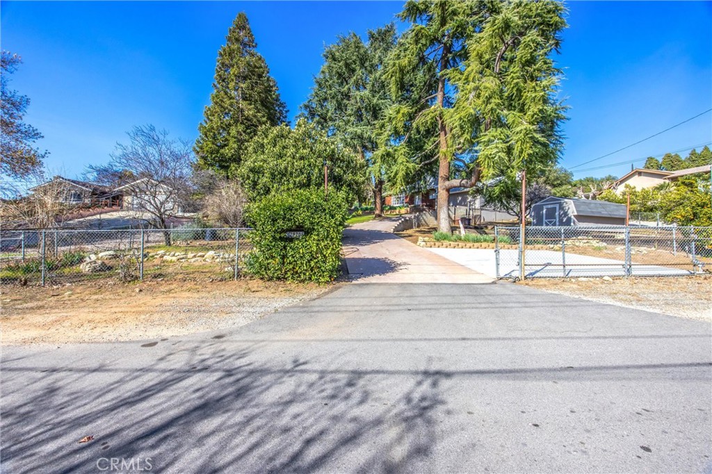 8705 Apple Tree Lane Cherry Valley, CA 92223 - Photo 50 of 72 Street level entrance with driveway on an uphill slope and rolling gates for access.