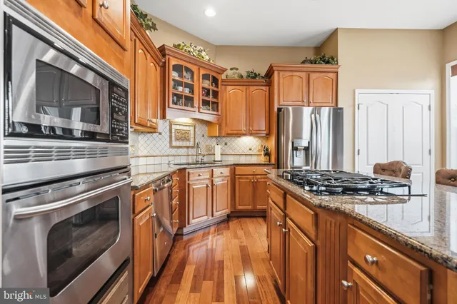 a kitchen with stainless steel appliances granite countertop a stove and a sink