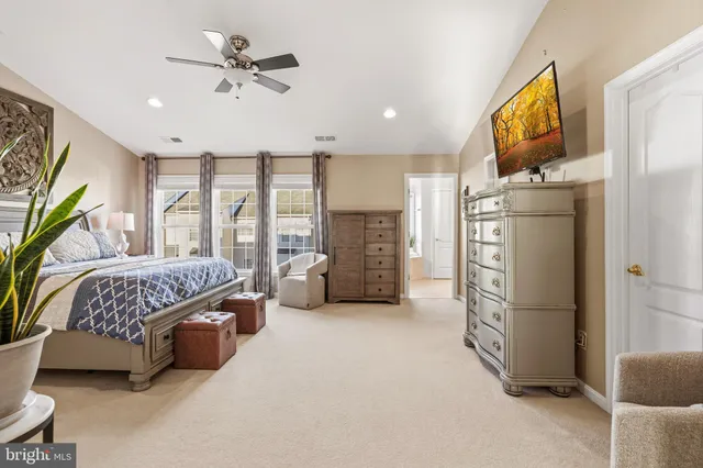 a bedroom with a bed dresser and a large window
