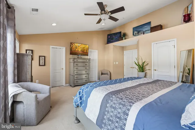 a spacious bedroom with a bed and ceiling fan