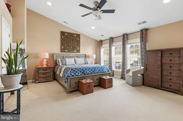 a bedroom with a large bed and windows