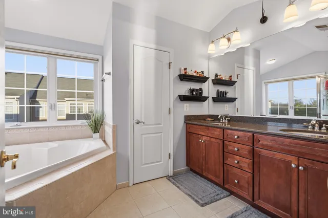 a spacious bathroom with a tub sink and mirror
