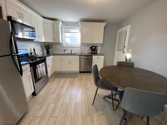 a kitchen with a table chairs microwave and cabinets