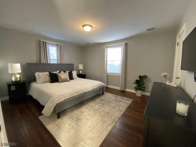 a bedroom with a bed and tv on the dresser
