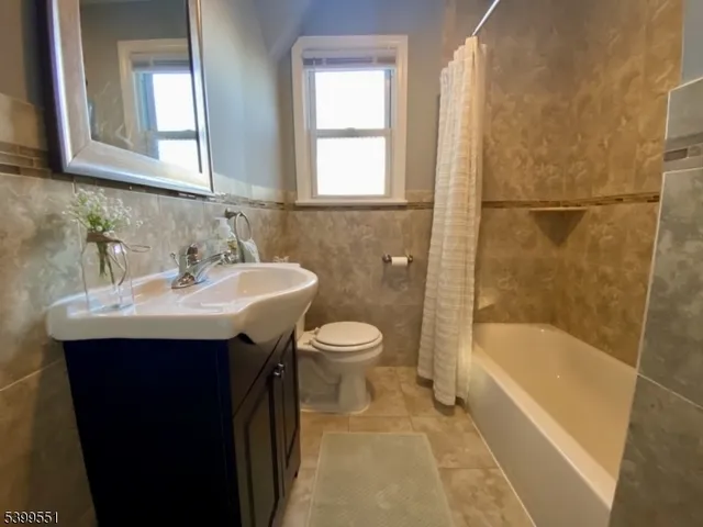 a bathroom with a sink mirror bathtub and toilet