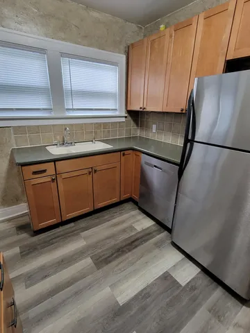 a kitchen with granite countertop wooden cabinets and white appliances