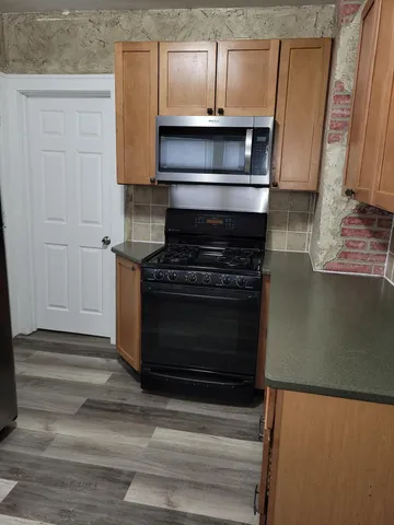 a kitchen with granite countertop a stove and a microwave