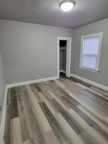 a view of a room with wooden floor and window