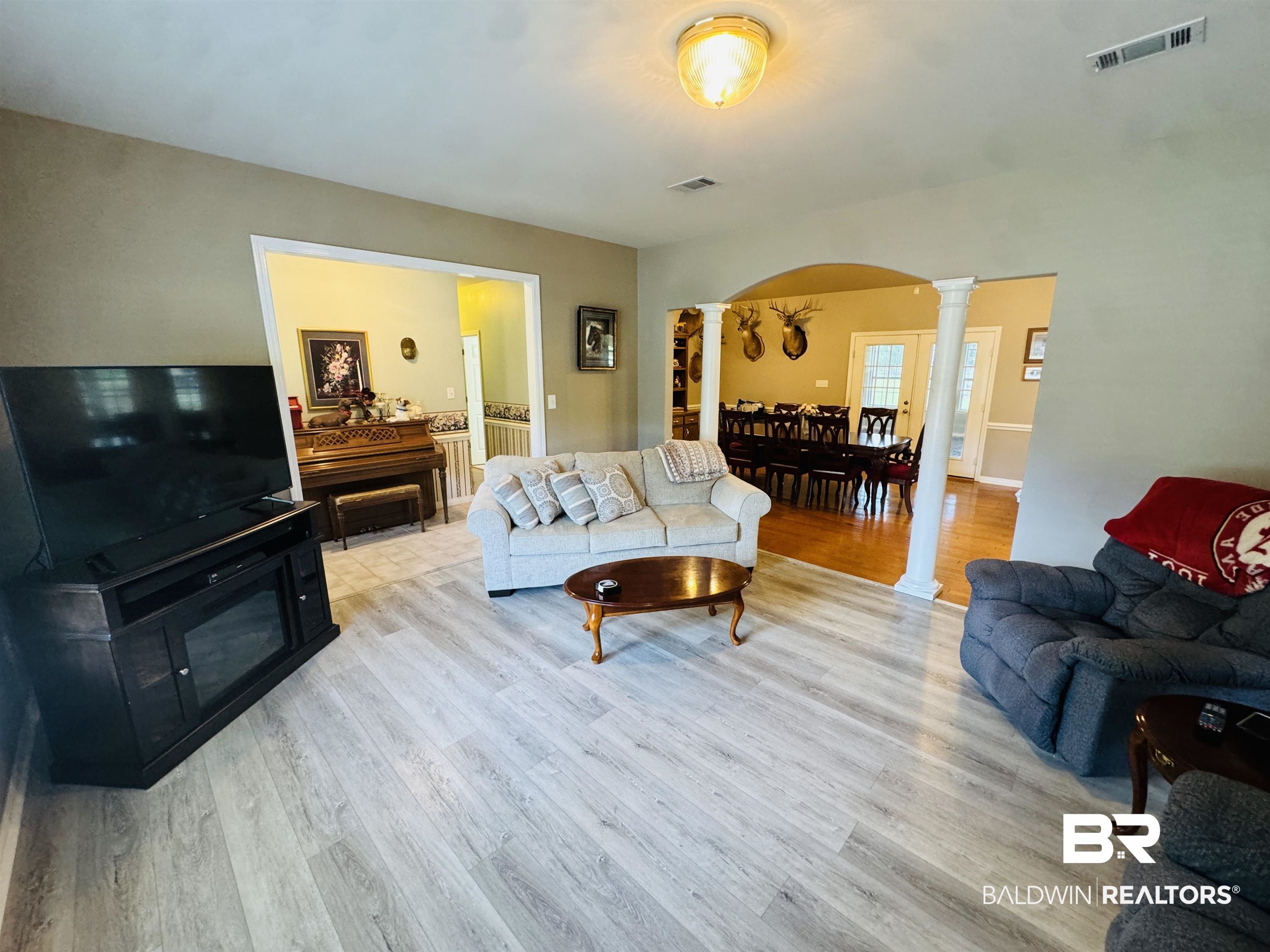 13795 White Road Silverhill, AL 36576 - Photo 20 of 99 Living area featuring ornate columns, arched walkways, and light wood-style floors
